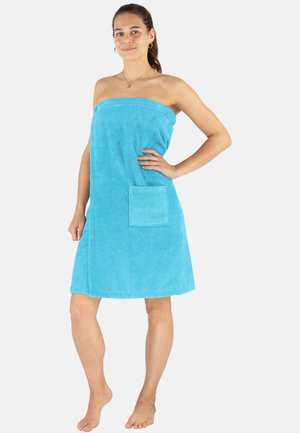 Turquoise towel dress made of terry cloth, featuring a strapless design and a front pocket. Soft texture with a hemmed edge.