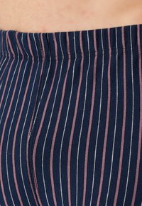 Puuvillaiset stretch-legginssit, joissa on pystysuorat tummansiniset, mauve- ja valkoraidalliset kuviot, leveällä joustavyötäröllä ja sileällä pinnalla.