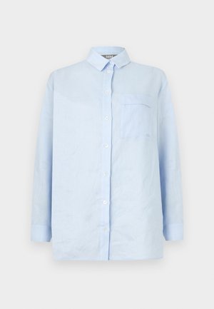 Camisa azul claro de manga larga con botones, cuello y un único bolsillo en el pecho sobre fondo blanco.