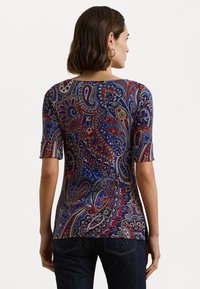 Top con motivo a paisley colorato in rosso, blu e giallo, maniche corte e orlo curvo. Realizzato in tessuto leggero.