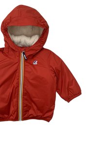 Giacca impermeabile rossa con cappuccio foderato in pelliccia sintetica, polsini elasticizzati e chiusura anteriore con zip gialla a contrasto. Patches con logo K-Way.