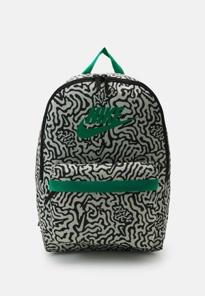 Zaino Nike con un motivo astratto a onde in bianco e nero, un logo verde, una tasca frontale con zip e una maniglia verde per il trasporto superiore.
