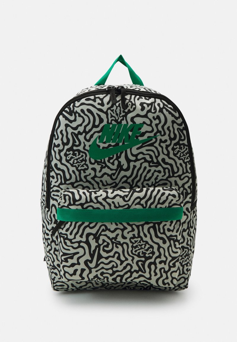 Nike-reppu, jossa on mustavalkoinen abstrakti aalto-kuvio, vihreä logo, etupaneelin vetoketjulla oleva tasku ja vihreä yläkantokahva.