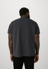 Dark navy short-sleeve t-shirt made of cotton. Rounded neckline and a straight bottom hem, with a smooth texture and minimal detailing.