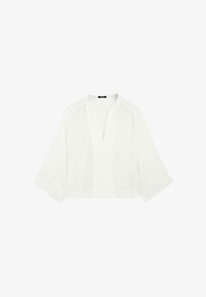 White cropped blouse made from lightweight fabric. Features a V-neckline and short, wide sleeves with a smooth texture and minimal design.