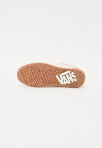Vans sneakersål med et struktureret brunt gummidesign, der har et hvidt logo i midten og greb med diamanter mønster.