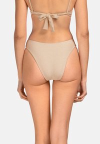 Beżowe bikini z wysokim stanem, o gładkiej fakturze i minimalistycznym designie. Posiada niskie wycięcie z tyłu oraz szerokie boki.