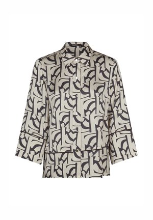 Button-up shirt with wide sleeves and black abstract geometric patterns on a light beige background.