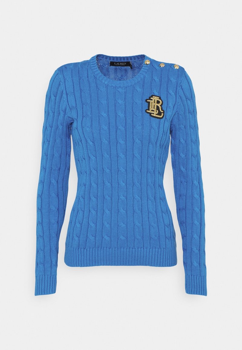 Blue cable-knit sweater with long sleeves, ribbed cuffs and hem, gold button accents on shoulder, and a black and gold logo patch.