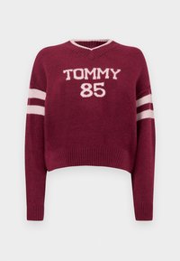 Veinipunane lühike kampsun V-kaelusega, millel valged "TOMMY 85" kirjaga tähed ja varrukatel valge triibuline muster. Pehme kootud tekstuur.