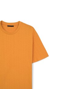 T-shirt a maniche corte, collo rotondo, di un vivace arancione con motivo a zigzag testurizzato, realizzato in morbido cotone. Etichetta: CALLIOPE.