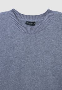 Maglione grigio lavorato a maglia con scollatura rotonda, etichettato "CALLIOPE", mostrato piatto su uno sfondo neutro.