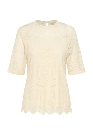 Cream lace top featuring short sleeves, a rounded neckline, and scalloped hem, showcasing intricate textured patterns throughout.