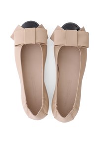 Nude leren ballerina's met een grote strikaccent op de ronde neus, voorzien van een zwarte glanzende kap en een zachte gewatteerde voering. Eenvoudig ontwerp.