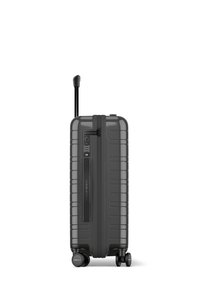 Valise rigide de couleur gris foncé avec une surface texturée, poignée rétractable, serrure à combinaison intégrée et quatre roues pour la mobilité.