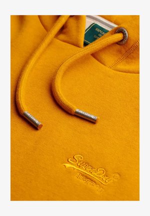 Felpa con cappuccio giallo senape con cordoncini, punte in metallo incise con "Superdry" e logo Superdry ricamato sotto lo scollo.