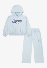 Sweat à capuche bleu clair avec cordon de serrage et logo "Converse" sur le devant, assorti à un pantalon de survêtement assorti avec poches cargo.