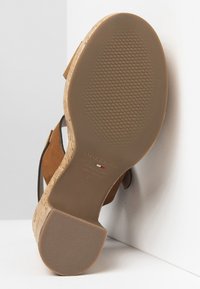 Sandale à plateforme en suede marron avec un talon en liège. La semelle est texturée, avec un fond en caoutchouc et une marque sur la semelle intérieure.