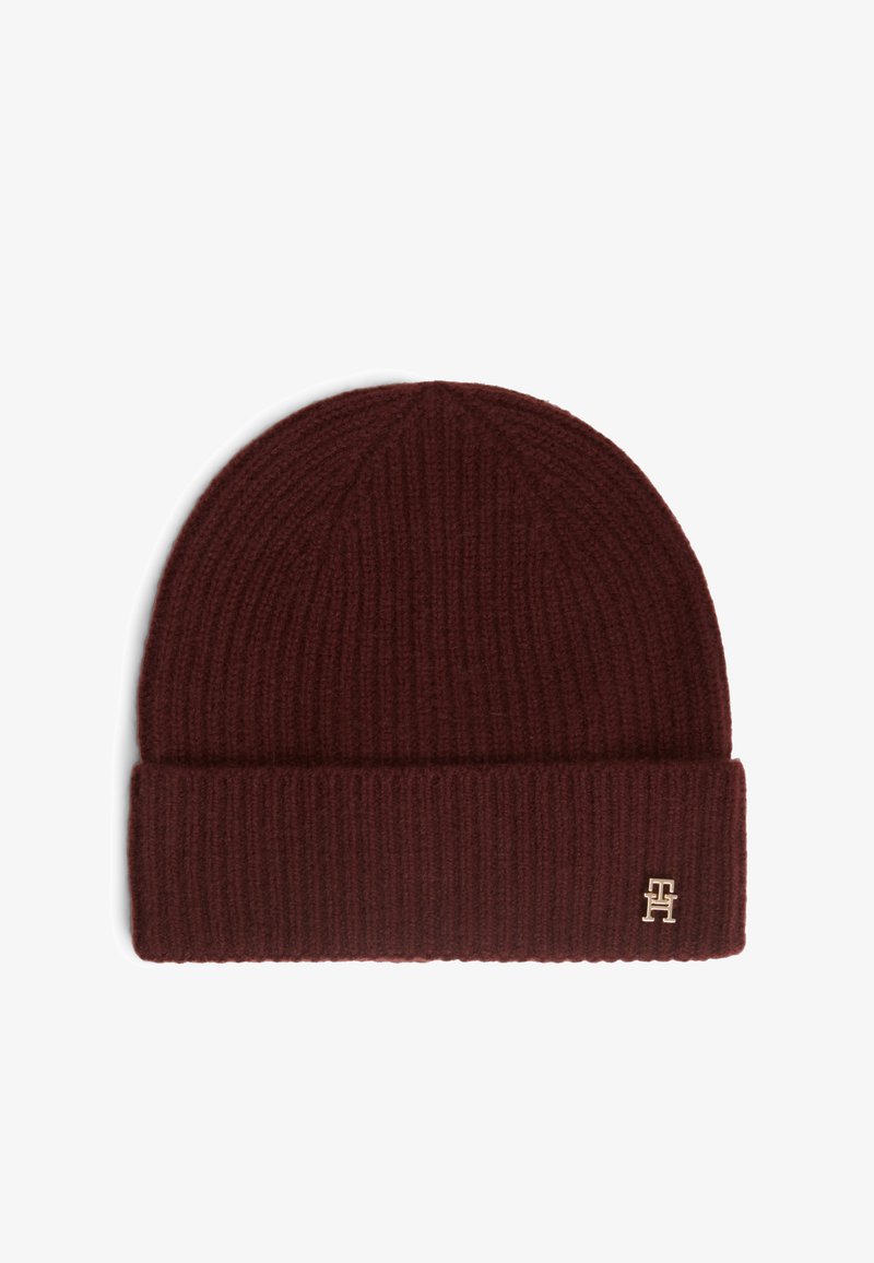 Bonnet en maille côtelée brun foncé avec revers plié et petit logo métallique sur le devant à droite.