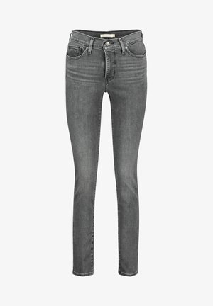 Jean slim gris en denim avec cinq poches, fermeture à bouton et zip, et légère décoloration sur l'avant des cuisses.