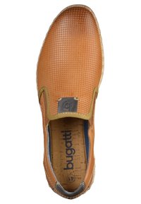 Bottines à enfiler tan avec dessus texturé, accents latéraux élastiques, semelle en liège et semelle en caoutchouc. Étiquette de logo près du talon dans une couleur atténuée.