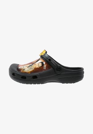 Sabot noir à enfiler avec un graphisme d’un personnage de Star Wars et un "T" jaune sur la bride réglable au talon.