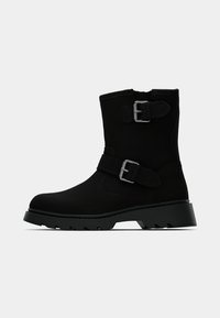 Μαύρα μποτάκια αστραγάλου με ματ φινίρισμα, διαθέτουν διπλές μεταλλικές αγκράφες και παχύ, ραβδωτό πέλμα για καλύτερη πρόσφυση. Απλός και λειτουργικός σχεδιασμός.