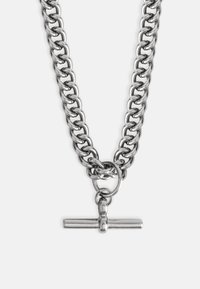 Ezüst fém lánc nyaklánc nagy szemekkel, T-alakú csattal és kör alakú záródási részlettel. A felület fényes és sima.