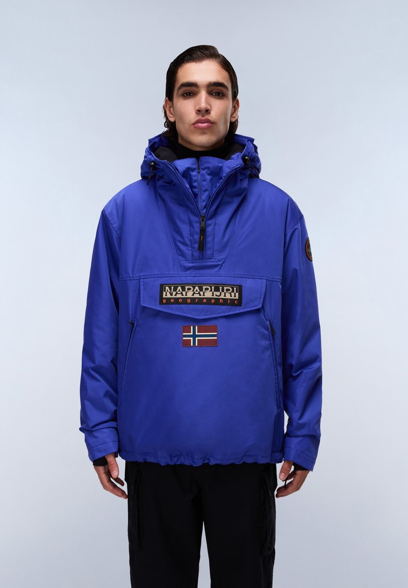 Blue waterproof pullover jacket with a high neck, front pocket, and a Norwegian flag detail. Includes a hood and elastic cuffs.