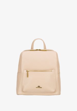Beige leather backpack with textured finish, gold hardware, top handle, and front zip pocket. Features a rectangular shape and minimalist design.