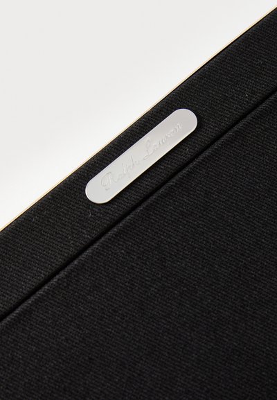 Czarna teczka z tkaniny z gładką, srebrną etykietą wygrawerowaną napisem „Ralph Lauren”. Charakteryzuje się eleganckim designem z subtelną fakturą i złotym akcentem.