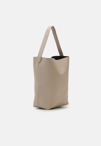 Sac fourre-tout en cuir beige avec une sangle large unique et un dessus ouvert montrant une doublure intérieure noire.
