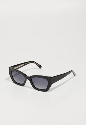 Black cat-eye sunglasses with gradient lenses, thick frames, and straight arms. Features a subtle logo on the temples.