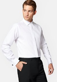 Biała koszula z długim rękawem i klasycznym kołnierzykiem, o gładkiej fakturze i mankietach na guziki, zestawiona z czarnymi, dopasowanymi spodniami dla uzyskania formalnego wyglądu.