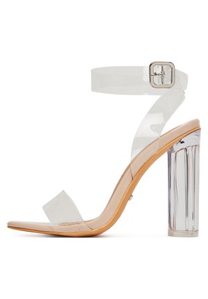 Průhledné sandály na vysokém podpatku s průhledným páskem kolem kotníku, širokým páskem u prstů a blokovým podpatkem s vertikálním žebrováním.