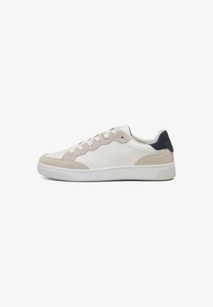 Baskets en cuir blanc avec des accents en suede beige, semelle en caoutchouc texturé, design à lacets et un onglet de talon bleu marine.