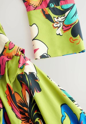 Farverigt stof med store blomster mønstre i pink, grøn, sort og blå. Glat tekstur med flydende designelementer og livlige nuancer.