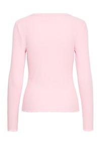 Gaiši rozā, ribota garām piedurknēm krekliņš ar nelielu salātu malu, redzams no aizmugures.