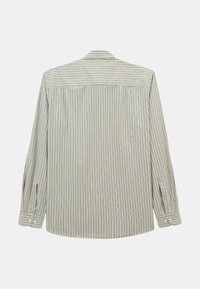 Chemise à manches longues et boutons avec des rayures verticales beiges et blanches, présentée de dos sur un fond uni.