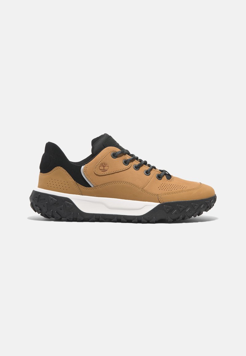 Bruine leren sneakers met zwarte accenten, ronde neus, vetersluiting, gewatteerde zwarte rubberen zool en geperforeerde details aan de zijkanten.
