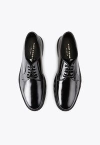 Scarpe eleganti in pelle verniciata nera con finitura liscia, punta rotonda, design con sei occhielli per allacciatura e suola in gomma nera testurizzata.