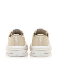 Sneakers in tela beige con forma arrotondata, suole in gomma bianca e dettagli di cucitura sottili. Presentano una linguetta sul retro per una facile calzata.