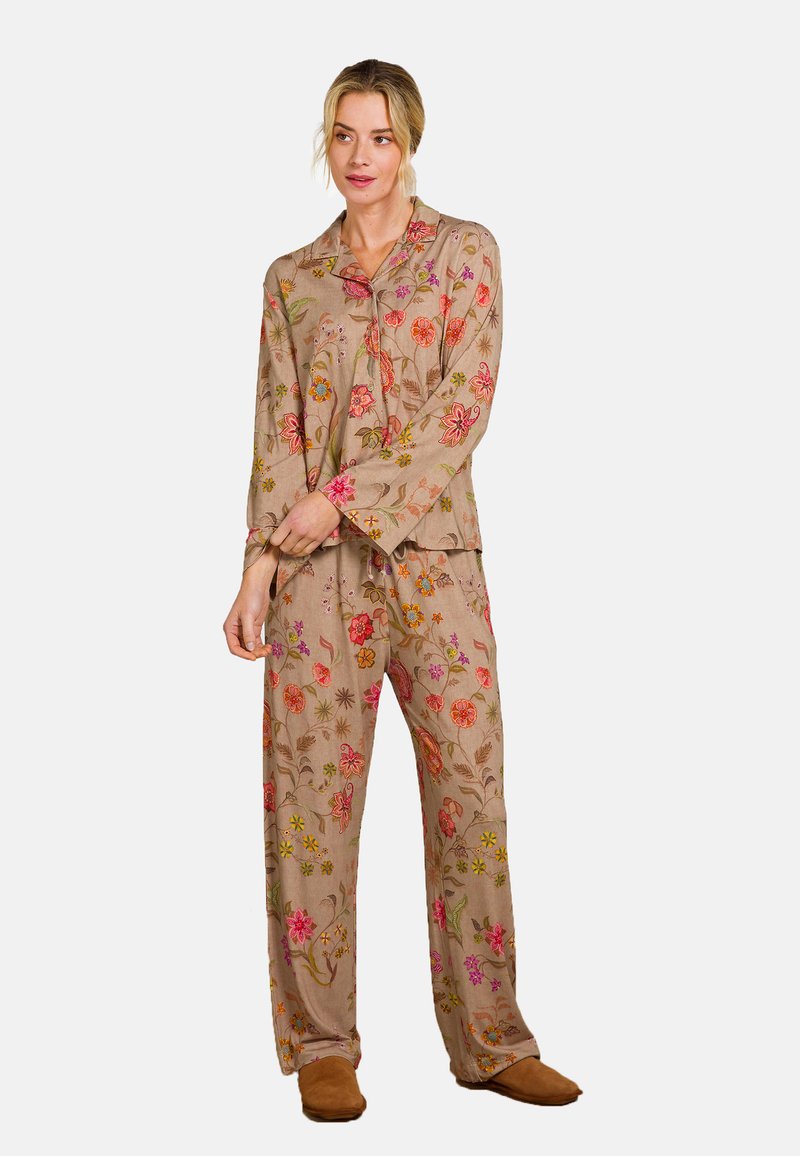 Beige pyjamastel met bloemenpatroon, met lange mouwen en losse broek. Borduursel met roze, rode en gele bloemen. Zachte stof textuur.