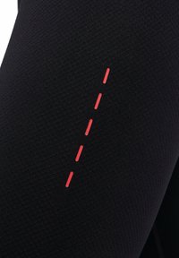 Zwarte sportleggings van textuurstof, met een verticale rode lijn in stippelstijl aan de zijkant als ontwerpelement.