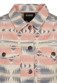 Patterned denim jacket featuring a pink, cream, and blue tribal design. Buttoned front, two chest pockets, and a classic collar.