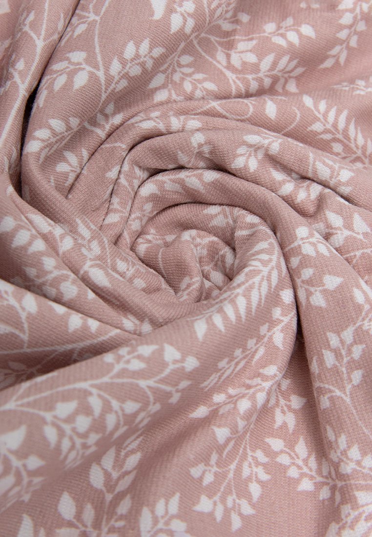 Helles rosa Gewebe mit einem weißen Blättermuster, das eine weiche Textur und eine glatte Oberfläche aufweist, in spiraliger Form angeordnet.