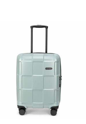 Valise rigide bleu clair avec poignée télescopique noire et quatre roues pivotantes noires, marquée « Epic » sur le devant.