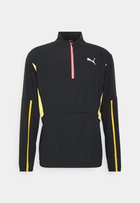 Maglietta nera a maniche lunghe con zip a quarto, con accenti gialli e rosa, caratterizzata da un logo Puma sul petto e dettagli in rete sulle maniche.