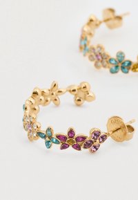 Χρυσά σκουλαρίκια κρίκοι διακοσμημένα με πολύχρωμα σχέδια λουλουδιών που περιλαμβάνουν ρόζ, μπλε και διάφανα πολύτιμα πετράδια. Περιλαμβάνει ετικέτα επωνυμίας.