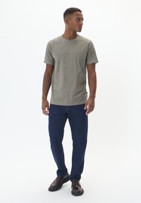 Gray short-sleeve T-shirt with a rounded neckline, paired with dark blue straight-leg jeans and brown leather shoes.